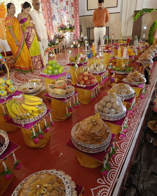 Seemantham row of plated fruit, sweet and laddu trays