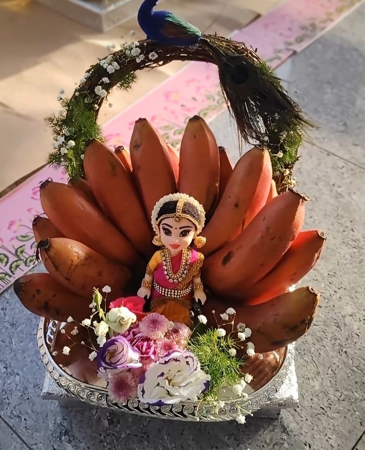 Red banana plated arrangement with peacock arch and doll