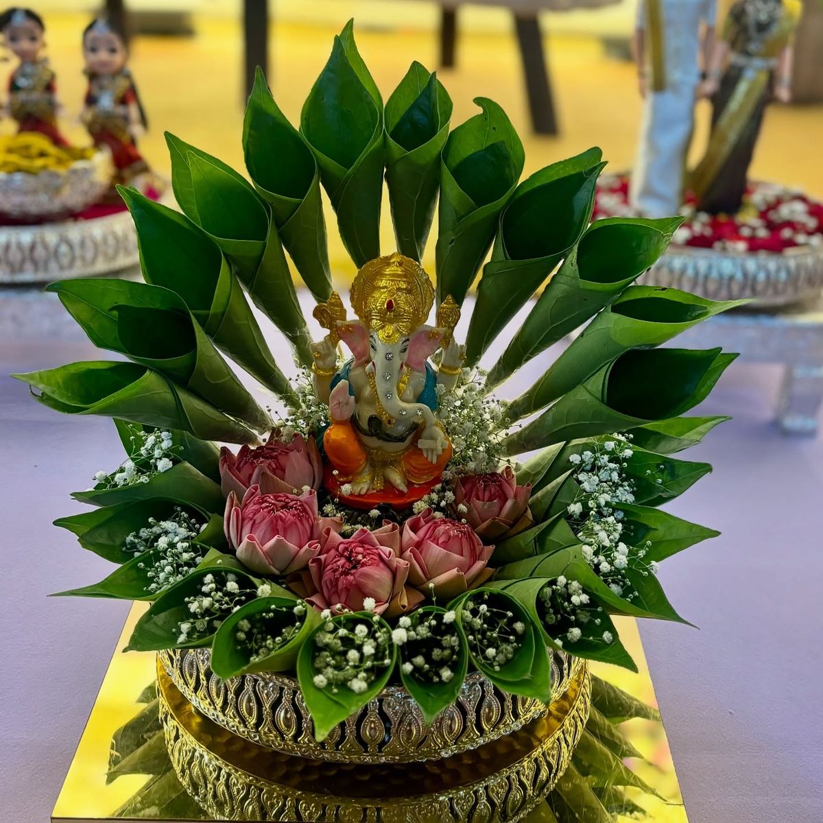 Ganesha idol on lotus and betel-leaf plated arrangement